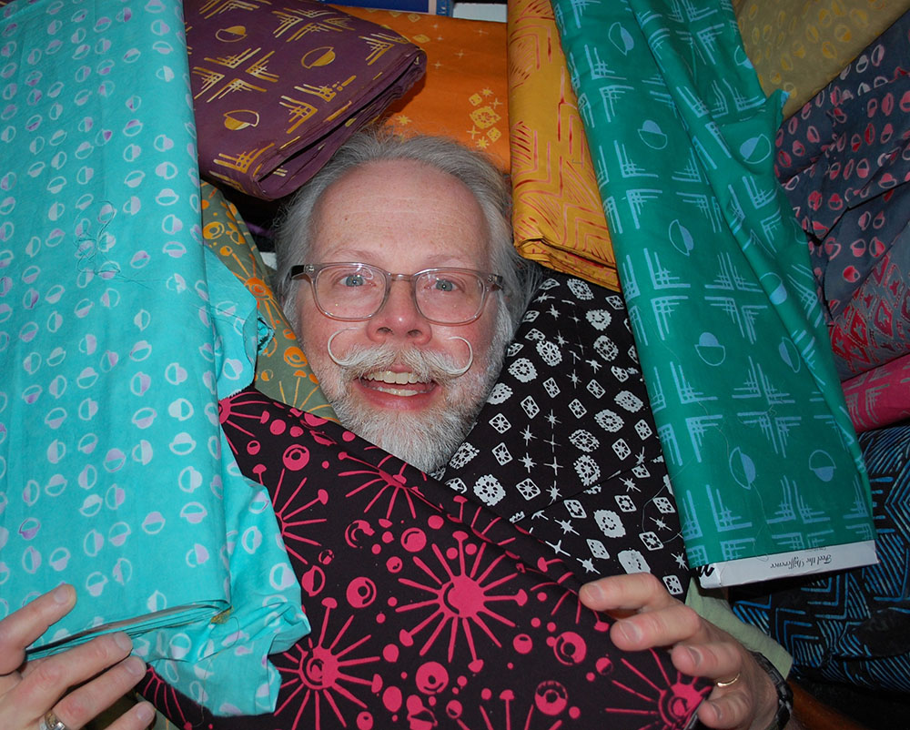 Scott with bolts of his fabric line, “Tie One On” for Banyan Batiks | Photo courtesy of the artist